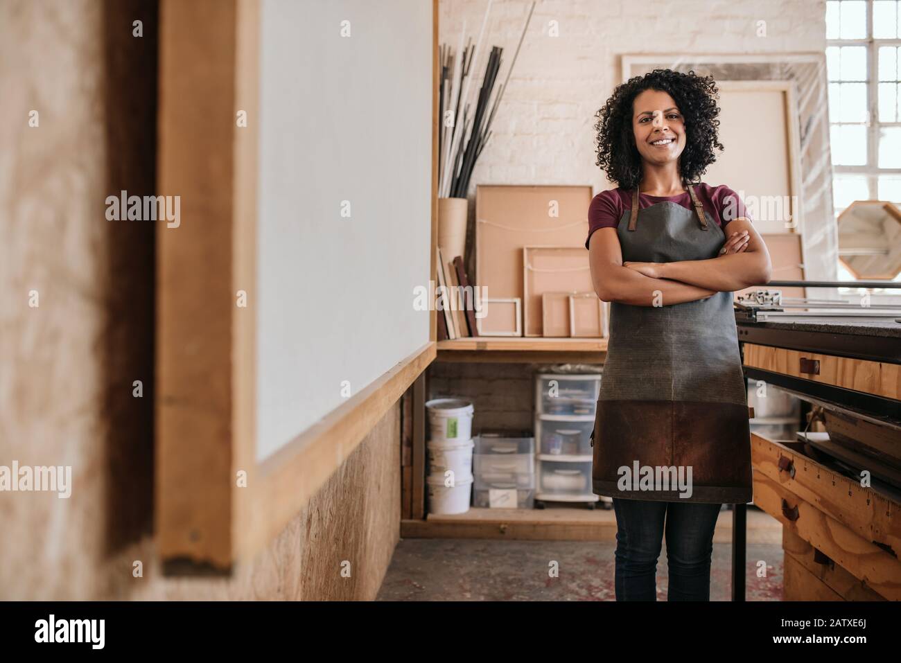 Young woman smiling while standing in her picture framing studio Stock Photo