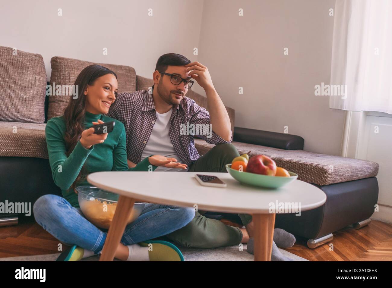 Couple is relaxing at home. They are watching tv Stock Photo Alamy