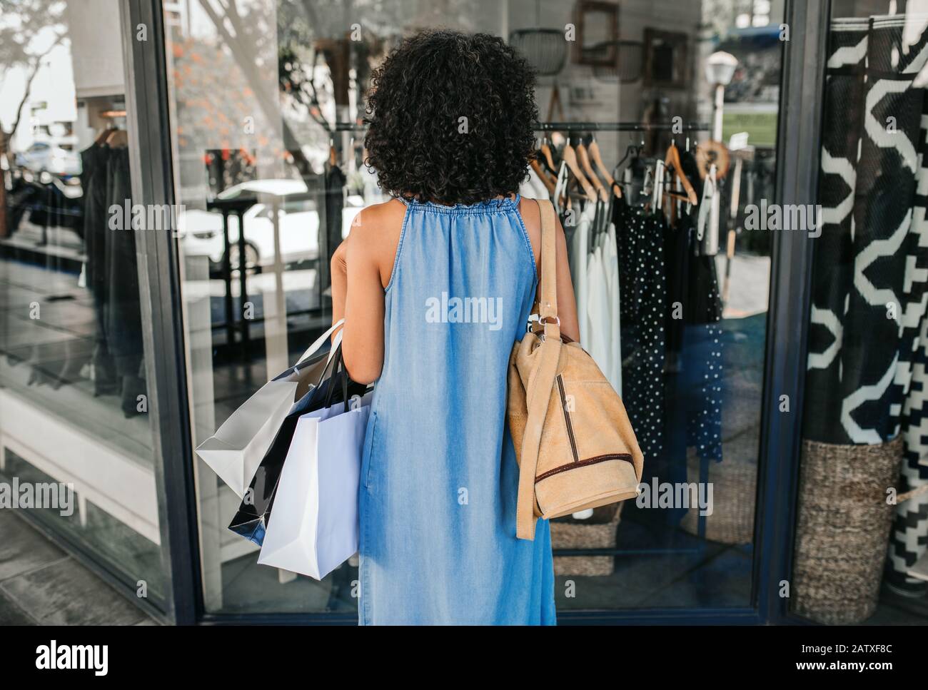 Woman looking at clothing on display in a boutique window Stock Photo