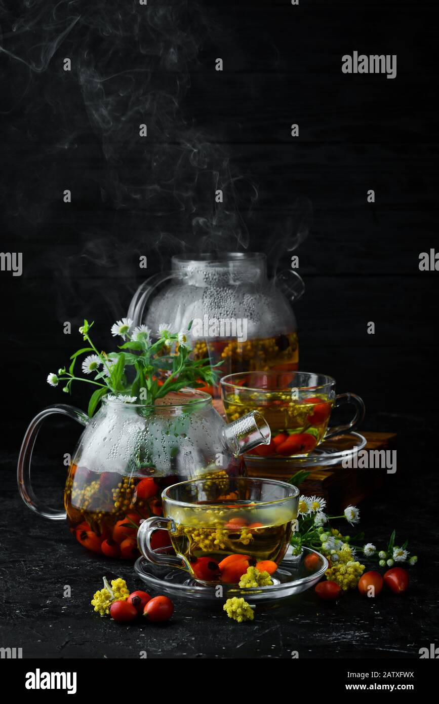 Chamomile and wild rose tea. Hot winter drinks. On a black background. Top view. Stock Photo