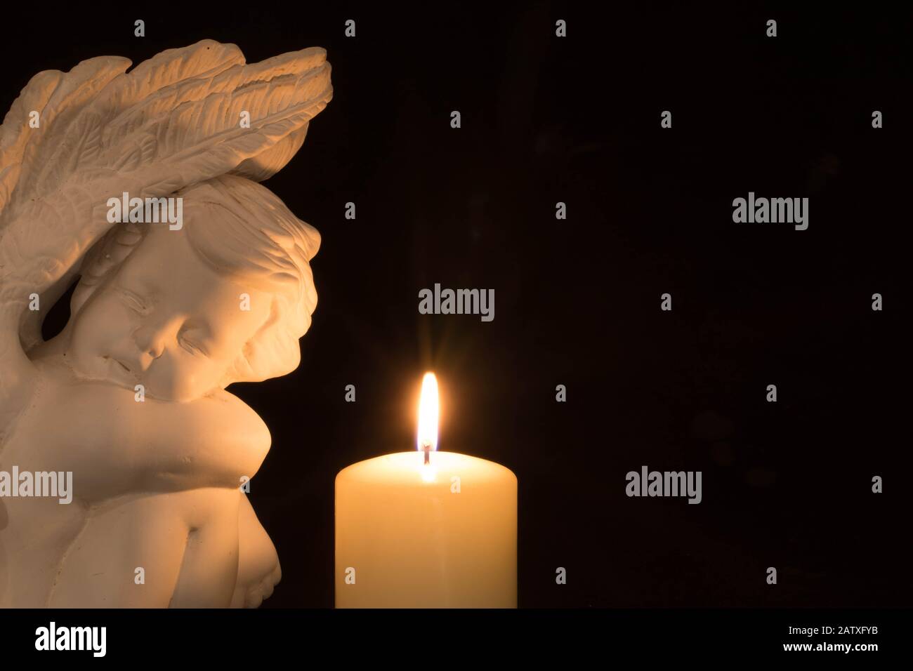 Angel and candle on dark background Stock Photo