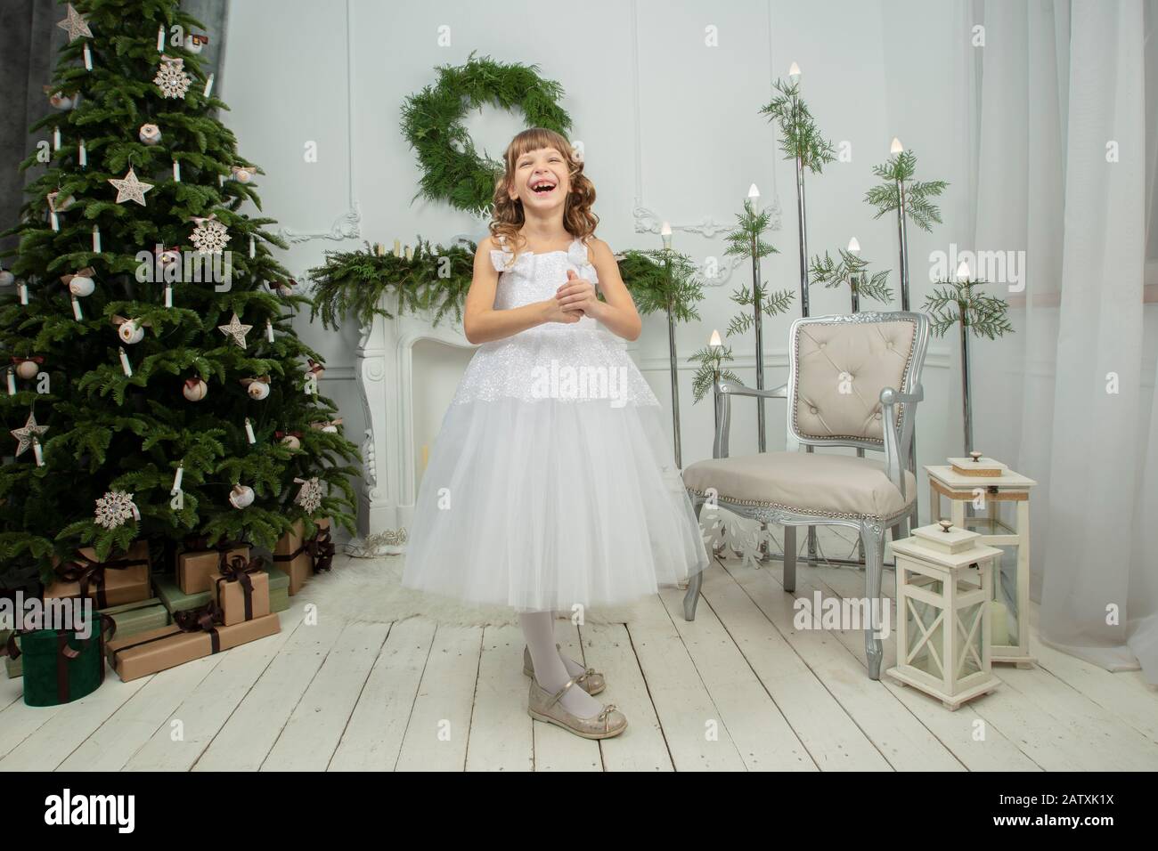 Elegant child at the Christmas tree. Little joyful girl in christmas Stock Photo