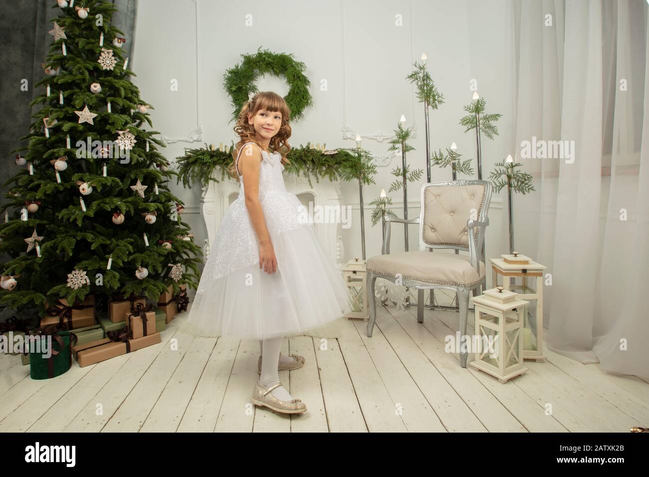 Elegant child at the Christmas tree. Little joyful girl in christmas Stock Photo
