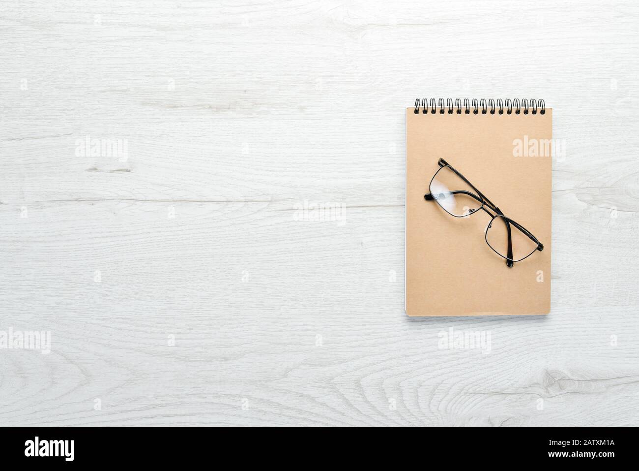 White office desk table with notepad and office supplies. Top view with