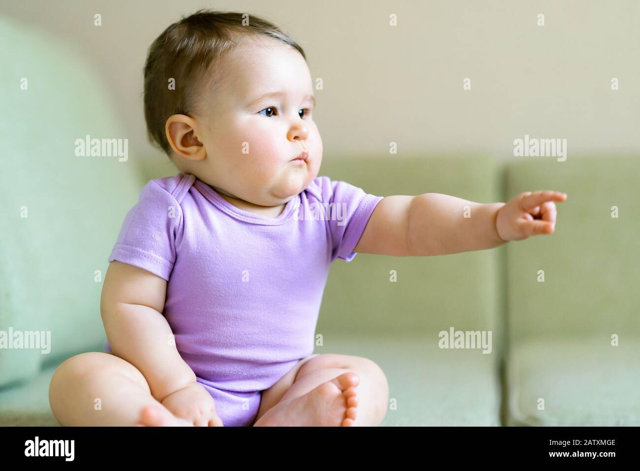 Baby held out his hand and points a finger at something Stock Photo
