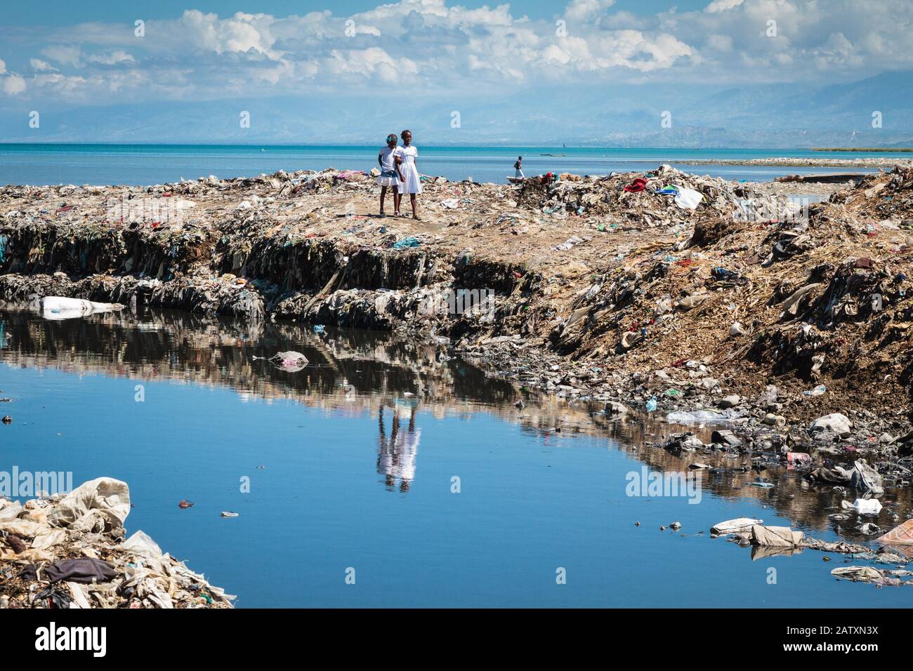 Girls on a huge mountain of rubbish on the coast, Cite Soleil, Port-au-Prince, Ouest, Haiti Stock Photo