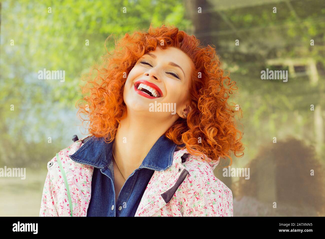 Beautiful red curly hair woman laughing, isolated outside. Happiness. Positive human emotion facial expression. Stock Photo
