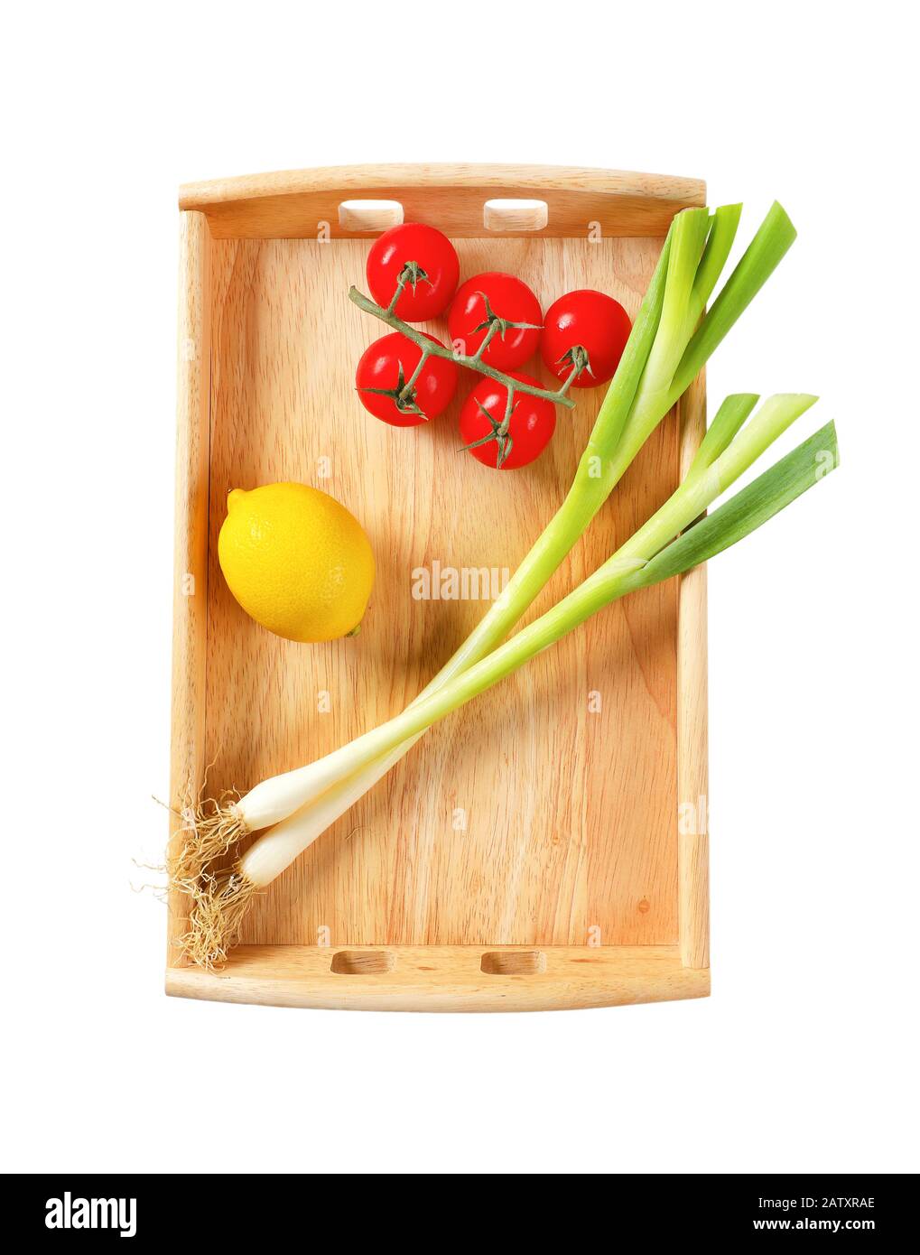 Spring onion, tomatoes and lemon on wooden serving tray isolated on white Stock Photo