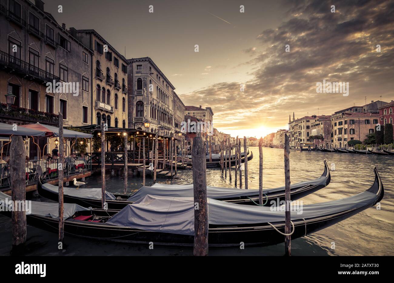 Grand Canal with gondolas at sunset, Venice, Italy. Scenic panoramic view of Venice in evening. Scenery of the main street of Venice at dusk. Beautifu Stock Photo
