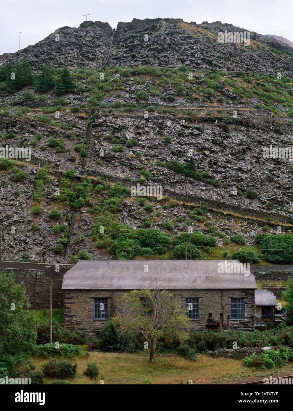 View SE of Pant yr Afon hydro-electric power station, Blaenau Ffestiniog, Wales, UK, with water pipeline descending the slate tips. Opened April 1904. Stock Photo