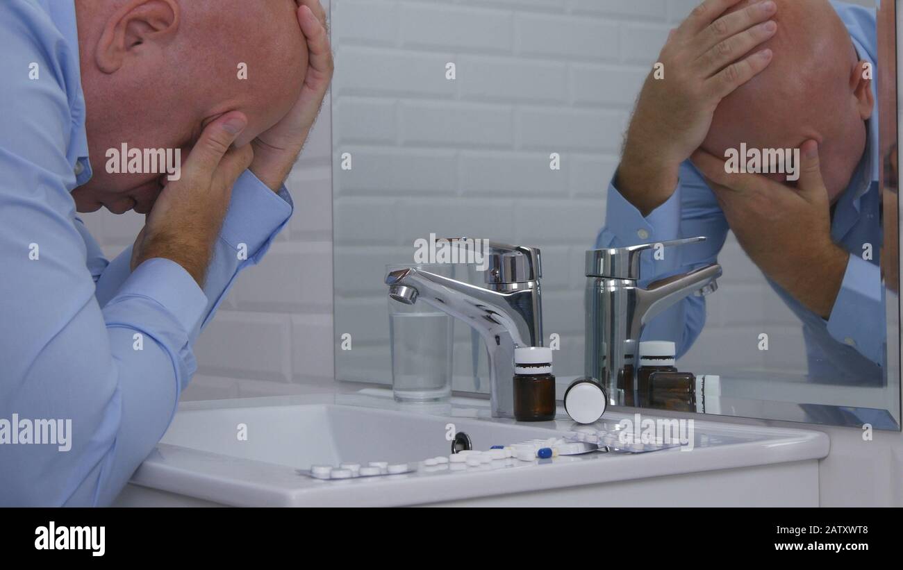 Image with a Businessman Suffering a Big Pain Looking to Medical Pills