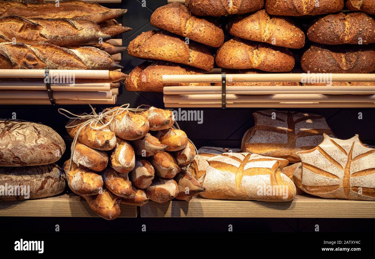 Loaves of bread on wooden shelves in baker shop, in Germany. Different types of bread. Tasty
