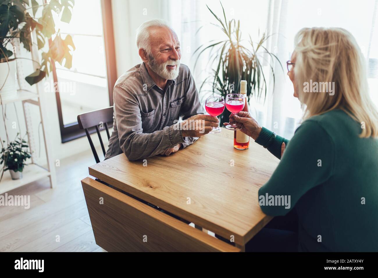 Senior couple at home drinking red wine Stock Photo - Alamy