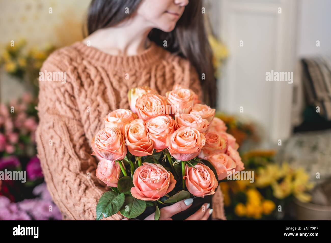 Woman florist holds a large beautiful bouquet of blooming pink roses in ...