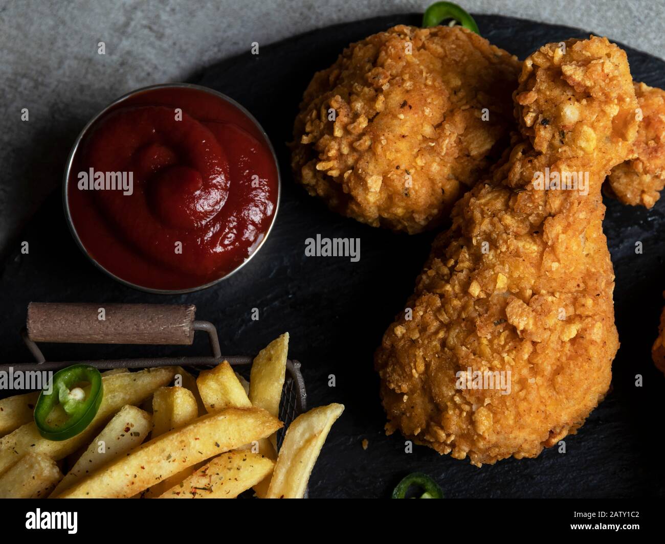 Breaded crispy fried chicken legs, french fries and sauce Stock Photo
