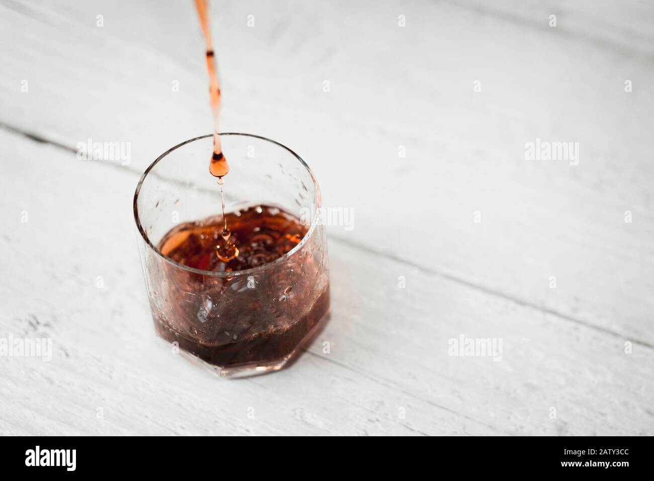 Pouring brown red liquid into glass Stock Photo Alamy