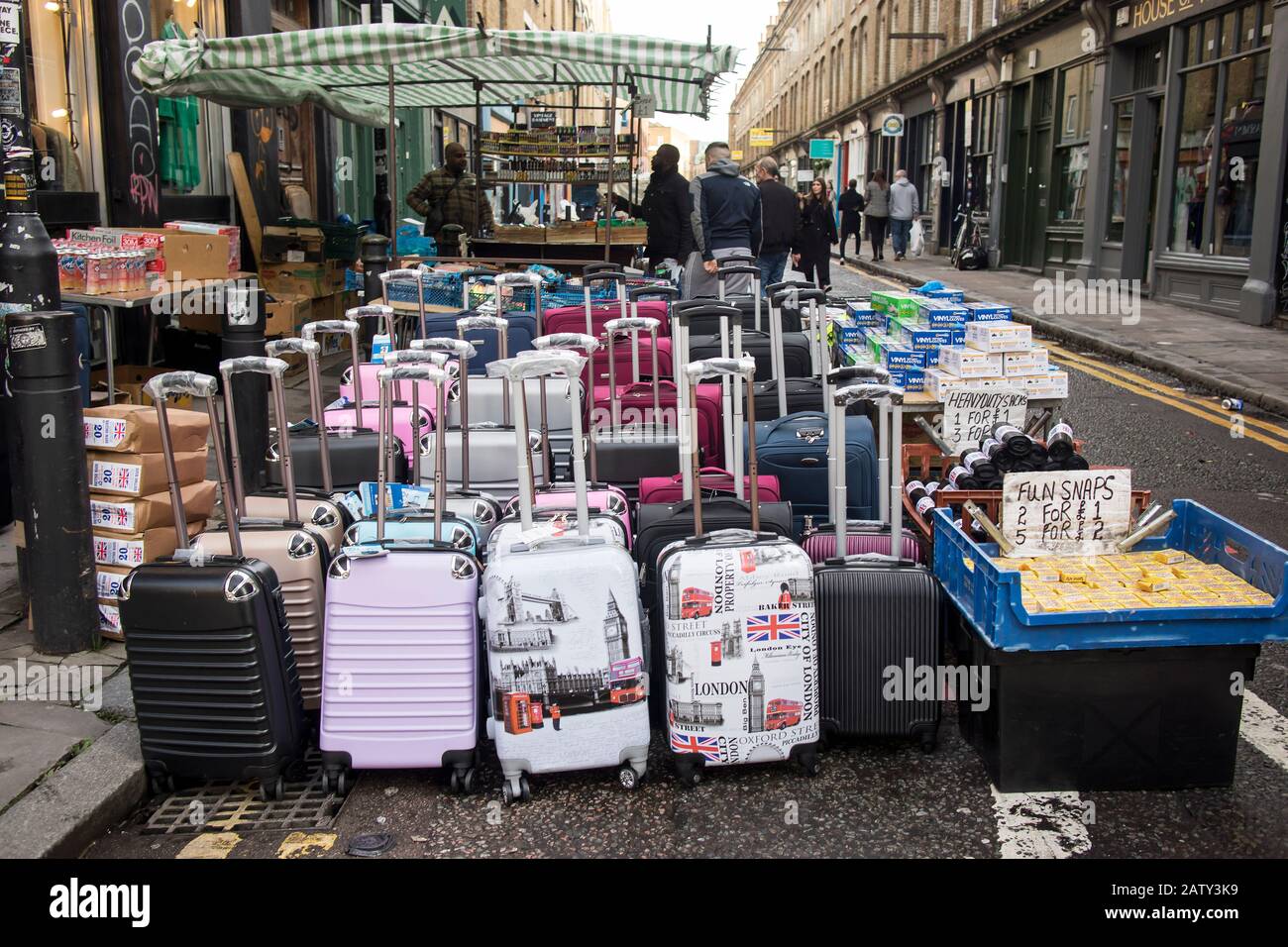 London, UK, - 23 December 2019, Cabin suitcases, garbage bags, and other items are on the road for sale in the street market. Sunday Brick Lane Market Stock Photo
