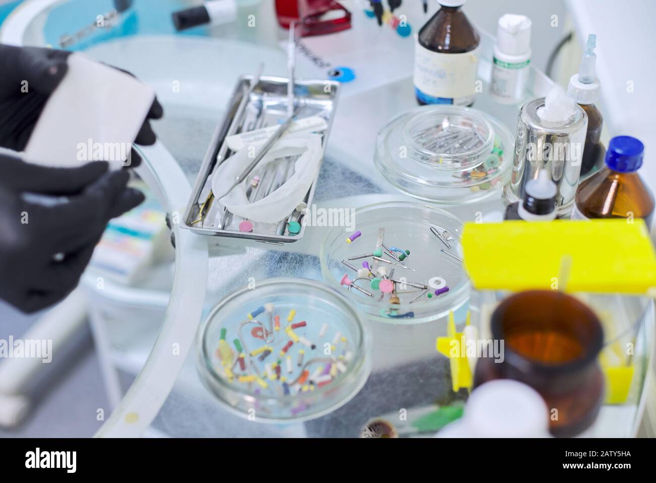 Close-up work at dentist doctor desk, dental composite sealing materials resins, professional dental instruments tools and medicines. Technology, medi Stock Photo