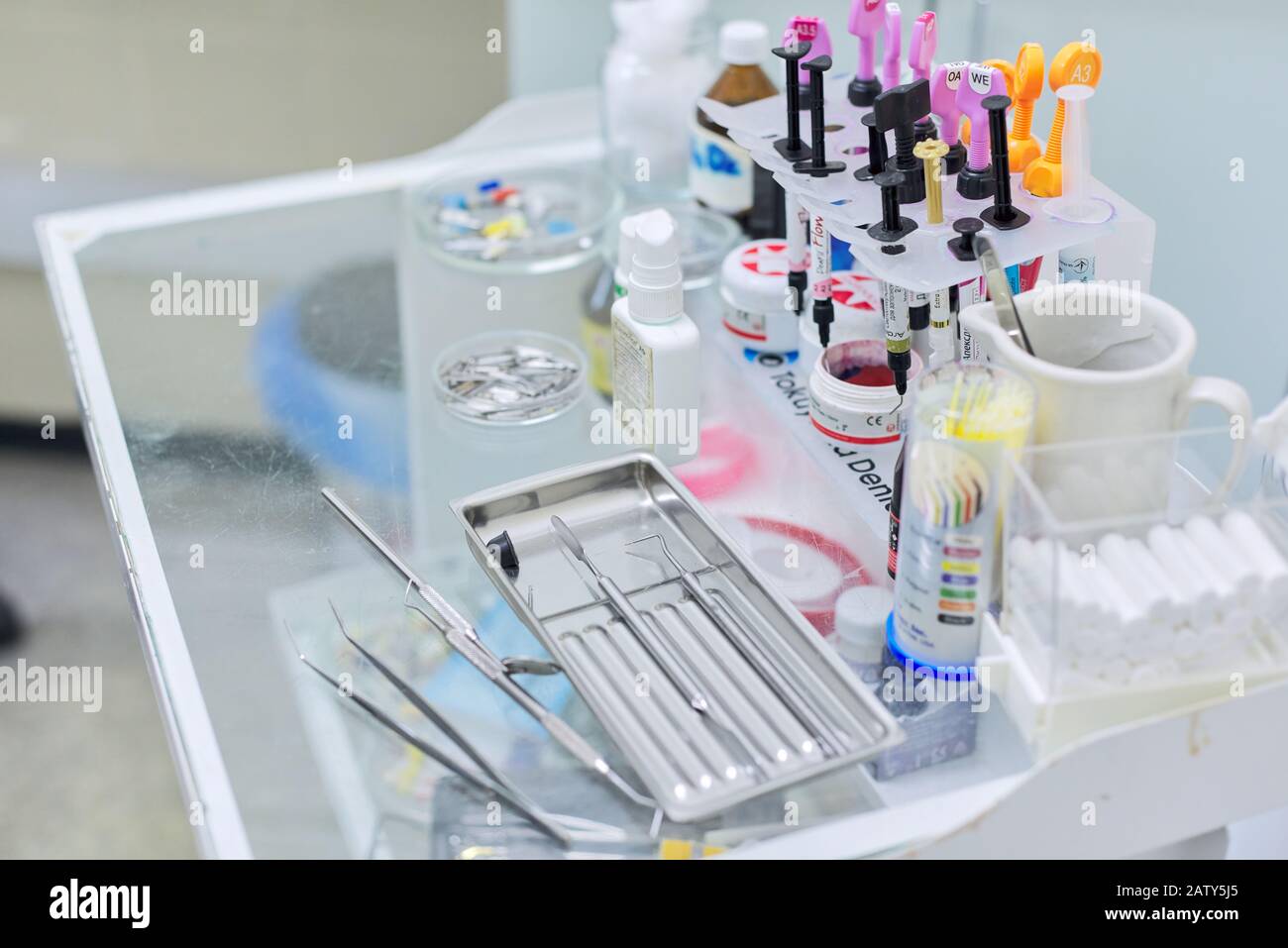Kyiv UA, 31-07-2019. Close-up of working desk in dentist office with dental composite sealing materials resins, various professional dental instrument Stock Photo