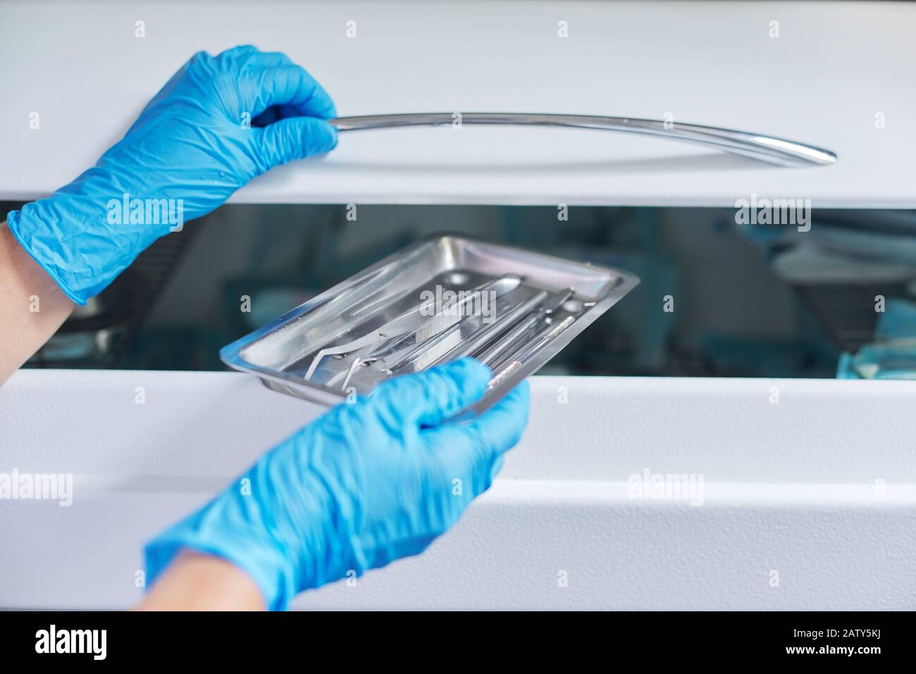 Female nurse doing sterilization of dental medical instruments in