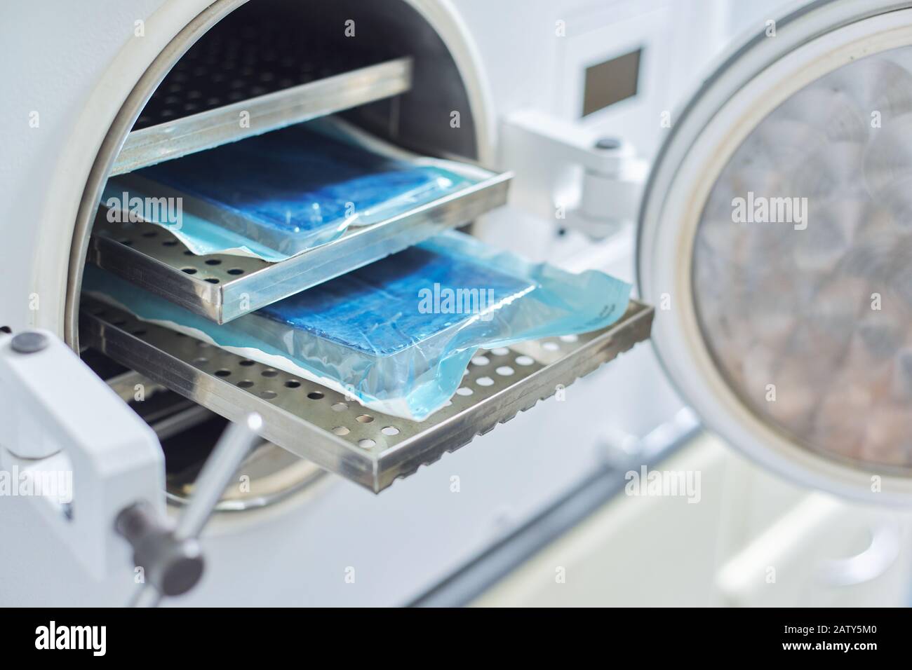 Sterilization of medical dental instruments in autoclave, closeup laboratory sterilizer in