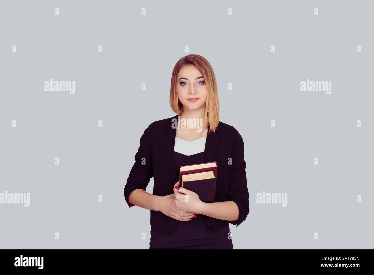 Smiling student carrying a backpack and holding stack of books isolated ...