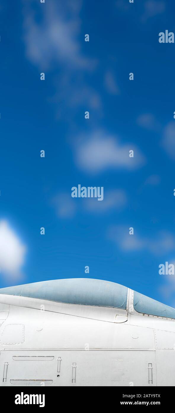 An editorial vertical panoramic  image of a jet aircraft canopy and blue midday sky. Stock Photo
