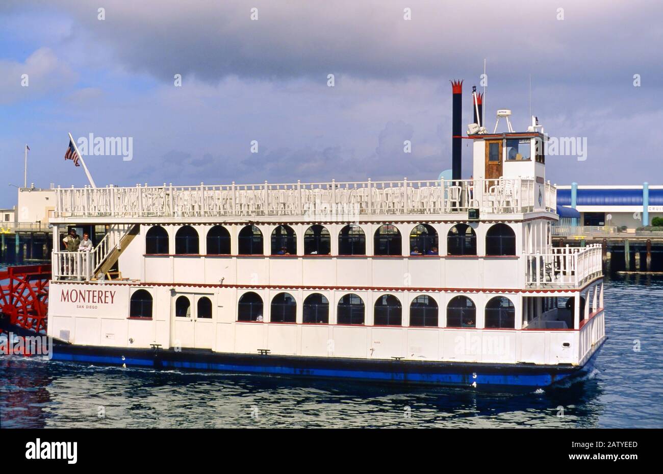 Steamboat Monterey in 1998. A few people visible on the deck and through the windows. Docks and buildings in the background. Stock Photo