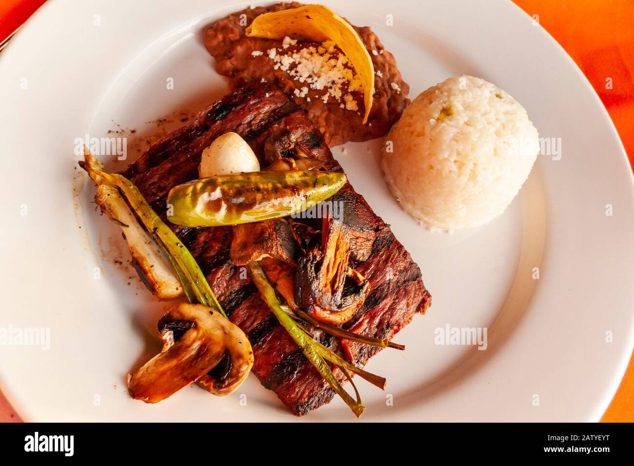 Carne Asada is a local favorite in Puerto Vallarta, Jalisco, Mexico.  Here it is plated with grilled peppers and served with a side of rice. Stock Photo