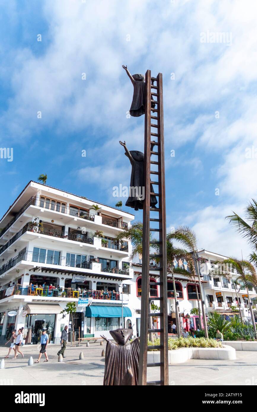 The sculpture called "In Search of Reason" by Sergio Bustamante (2000) shows figures climbing up a ladder, Puerto Vallarta. AKA En Busca de la Razón. Stock Photo