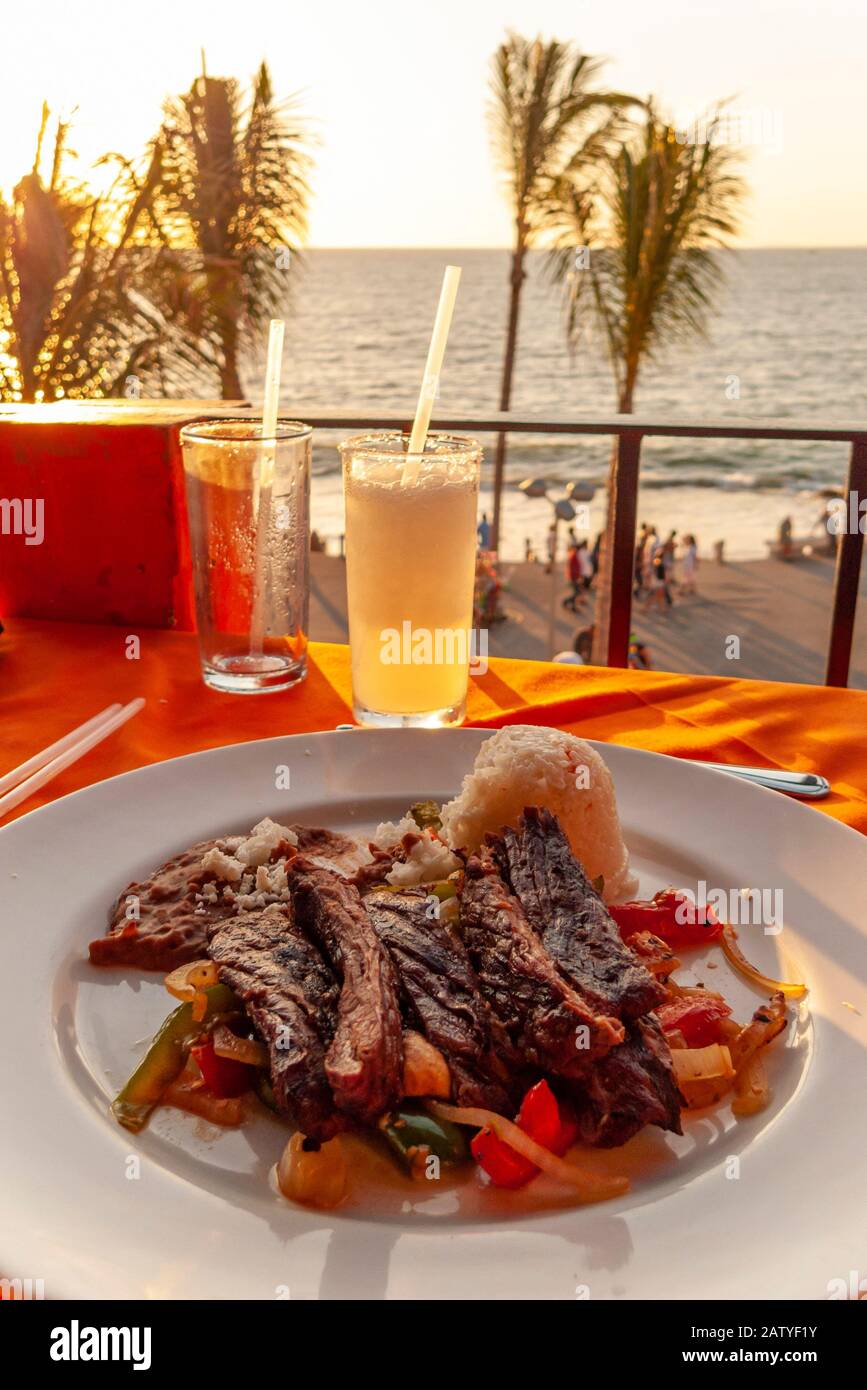 Carne Asada fajitas is a local favorite in Puerto Vallarta, Jalisco, Mexico.  Here it is plated with grilled peppers and served with a side of rice. Stock Photo
