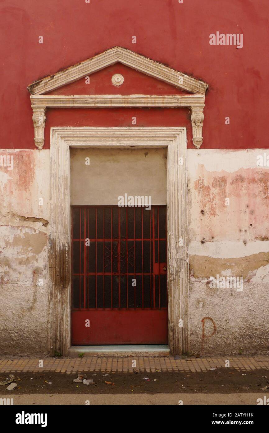 A typical colonial building with a red and white color scheme and a wooden door in Hunucma, Mexico. Stock Photo