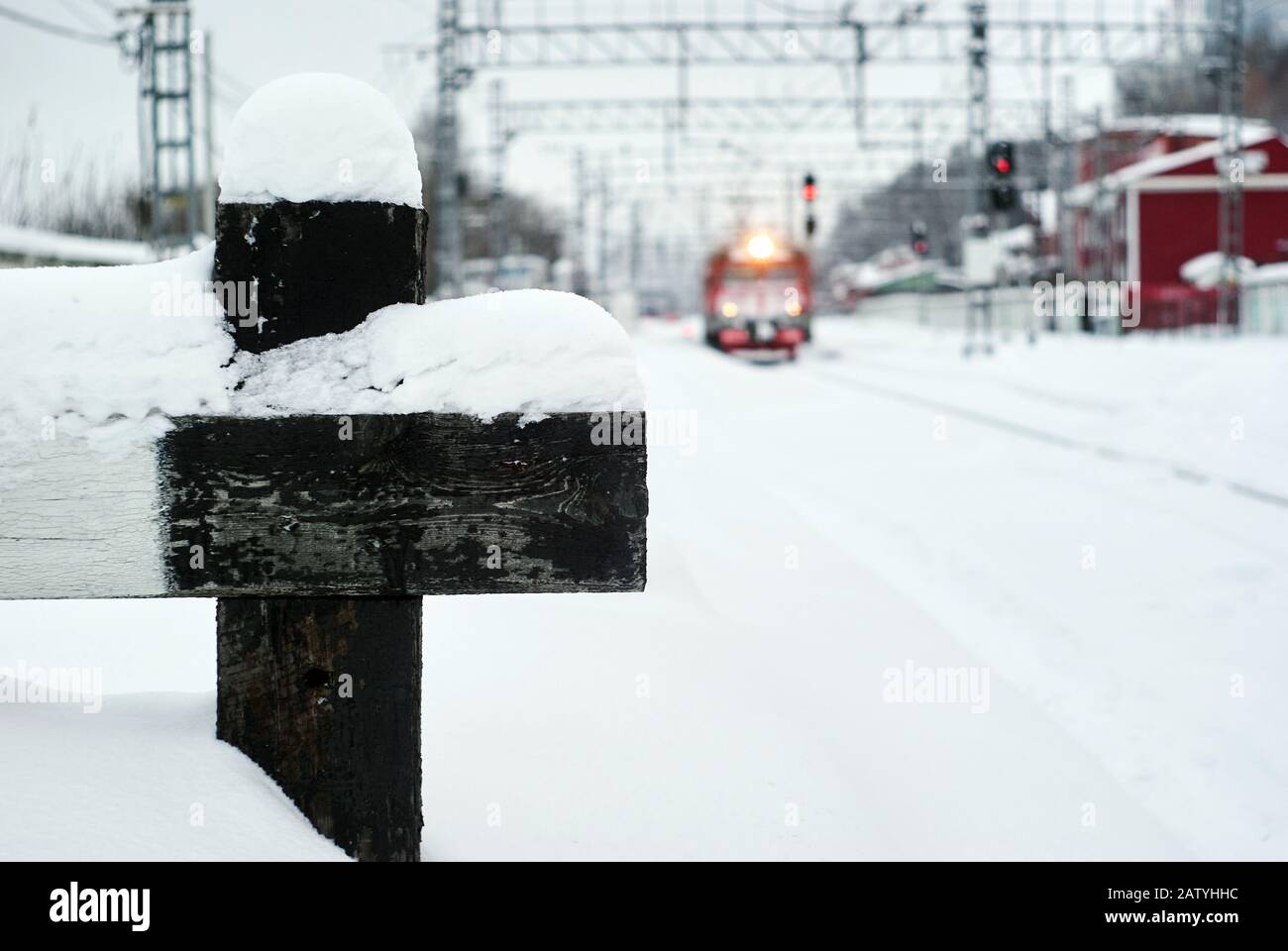 blurred winter landscape of a railway junction with a fragment of a buffer stop of a сatch point in sharpness in the foreground Stock Photo
