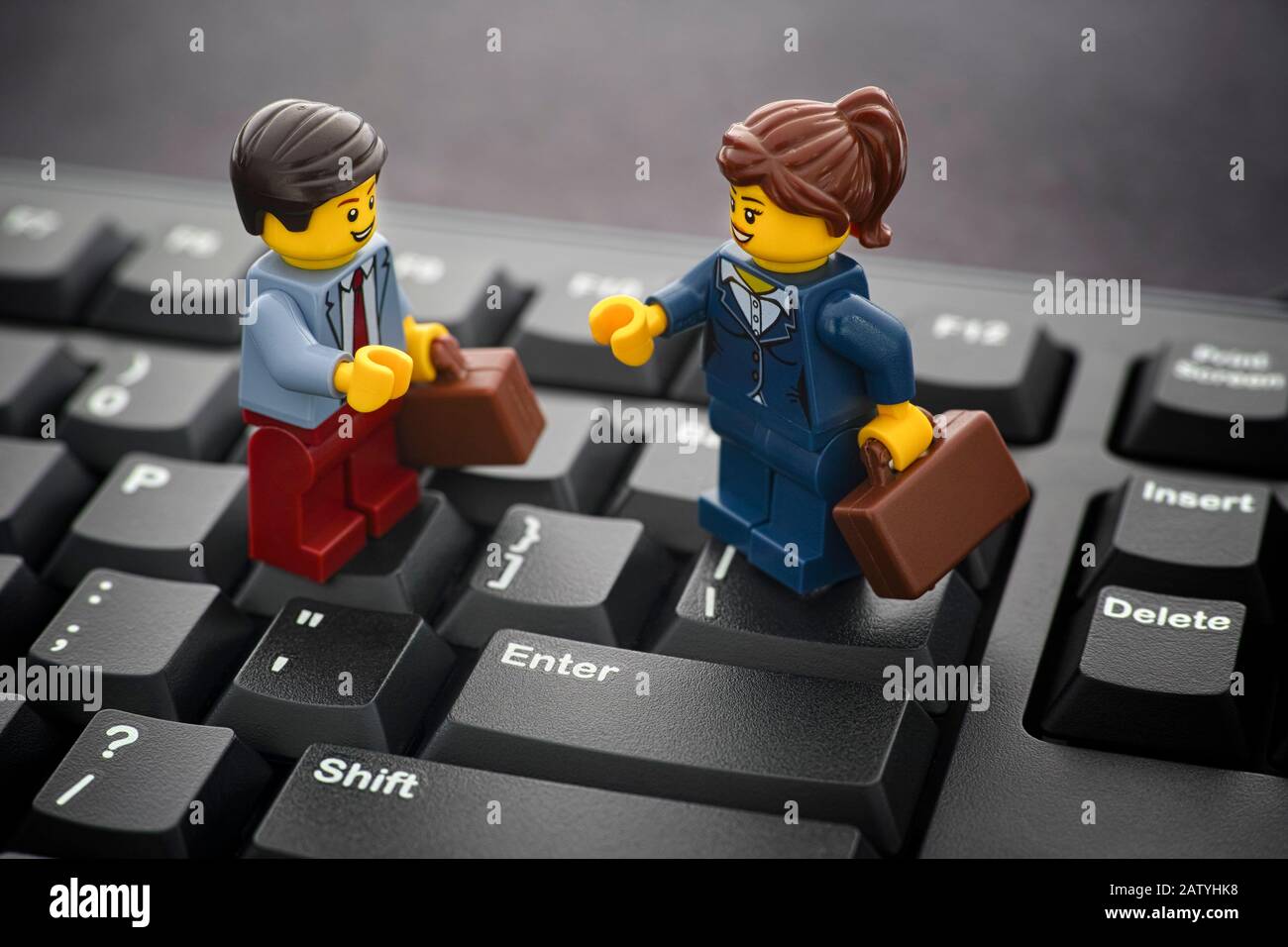 Tambov, Russian Federation - January 24, 2020 Lego businessman and businesswoman minifigures standing on a black computer keyboard. Stock Photo