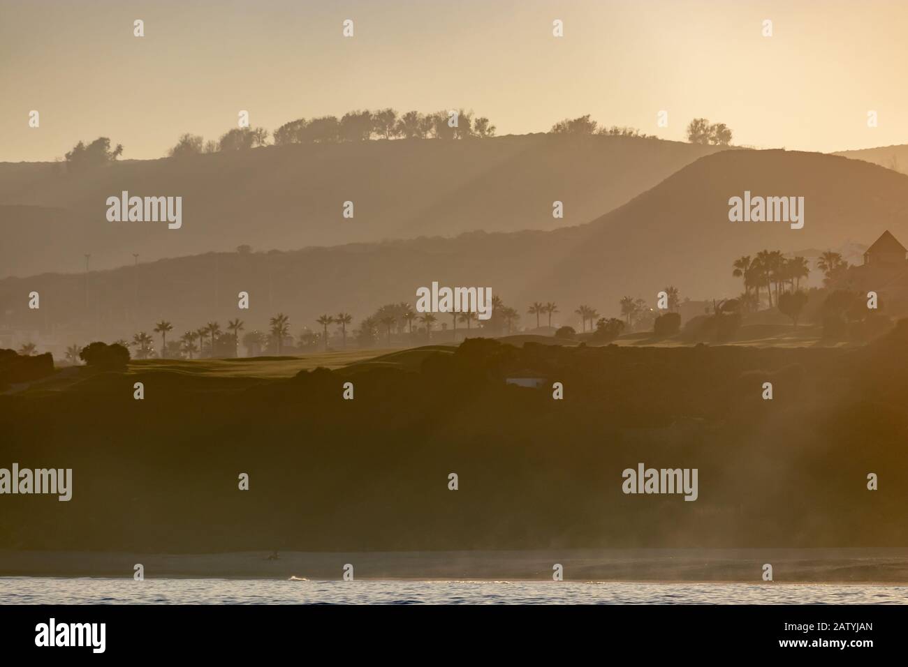 Misty Sunset over the Alcaidesa golf terrains on Spanish Costa del Sol Stock Photo