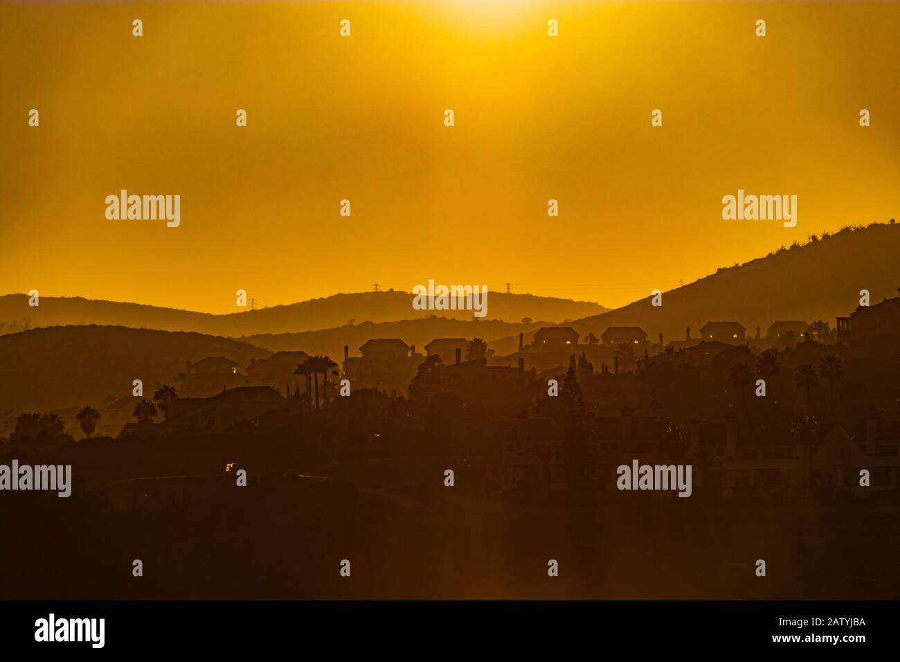Orange sunset and andalusian hills with La Alcaidesa village seen in the background Stock Photo