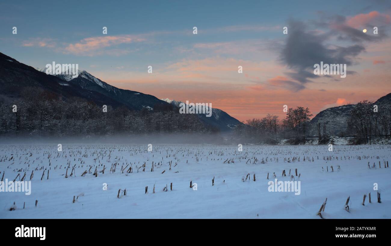 Picture of a winter sunset over a field in the Alps. Stock Photo
