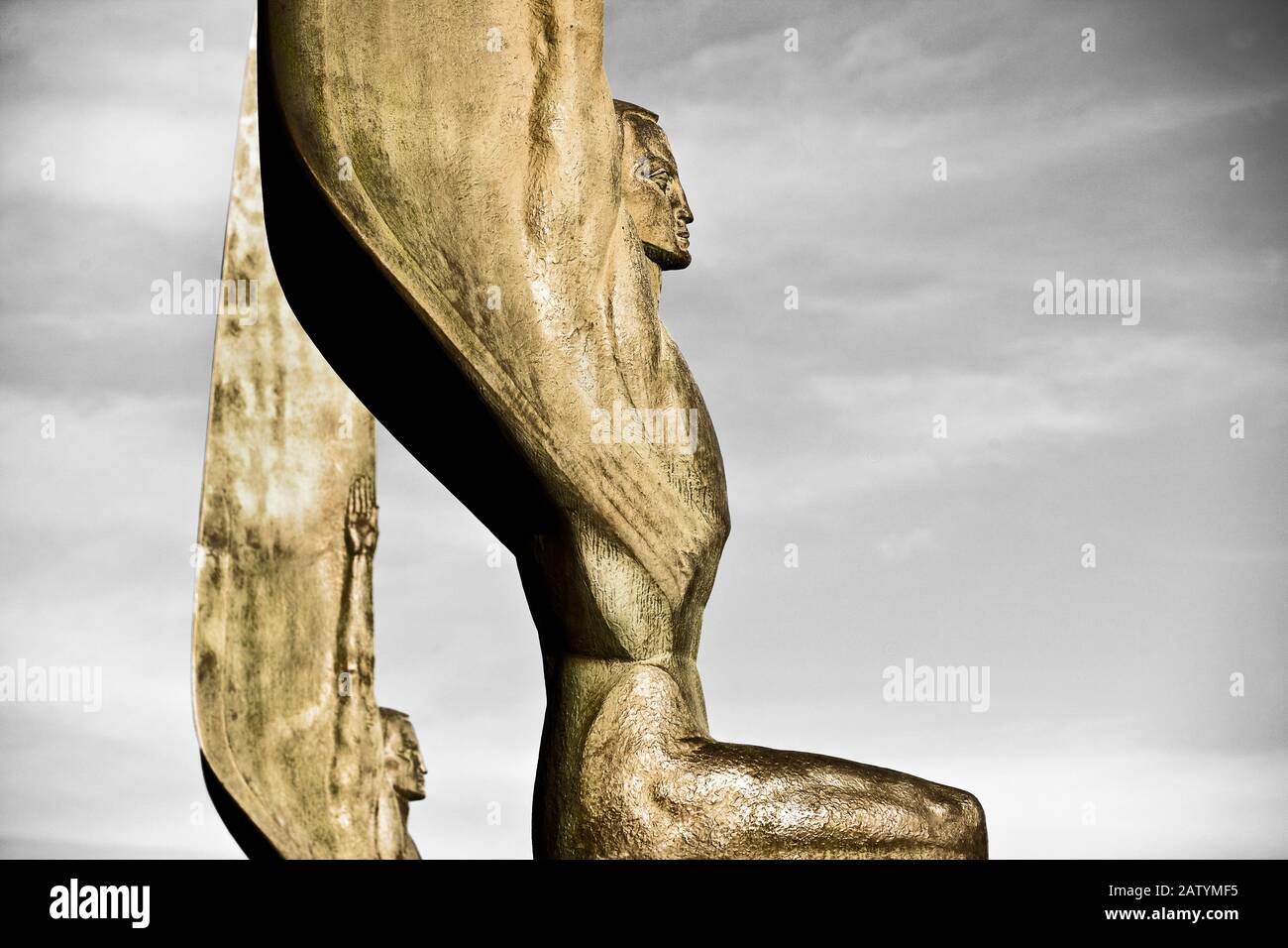 Two gold-colored statues reaching towards the sky Stock Photo - Alamy