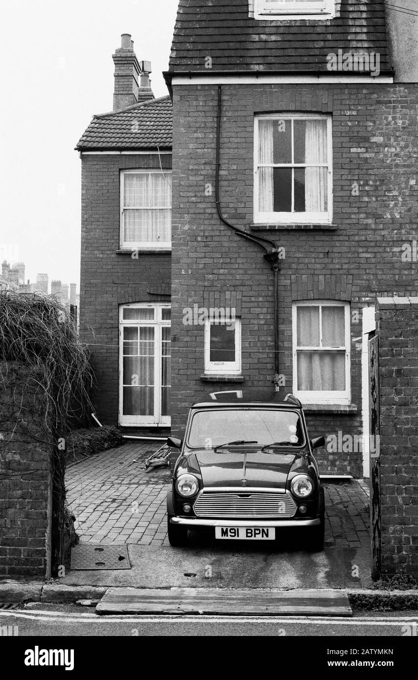 'SO BRITISH' A MINI BRITISH LEYLAND CAR PARKED FRONT OF A TYPICAL SEMI-DETACHED HOUSE - WORTHING SUSSEX ENGLAND GREAT BRITAIN - BLACK AND WHITE SILVER FILM PHOTOGRAPHY © Frédéric BEAUMONT Stock Photo