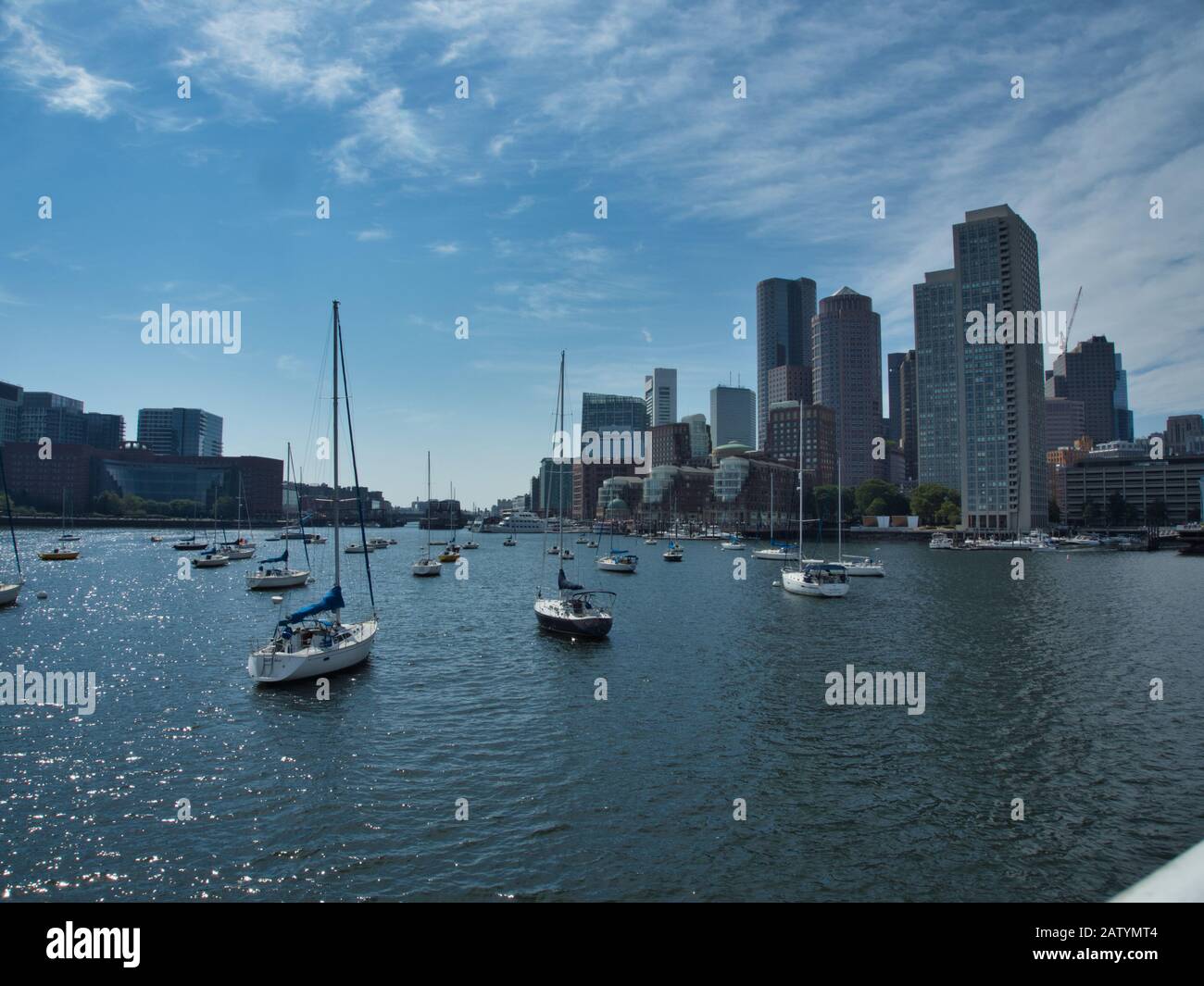 Boston Massachusetts harbor and city skyline over water with sailboats Stock Photo