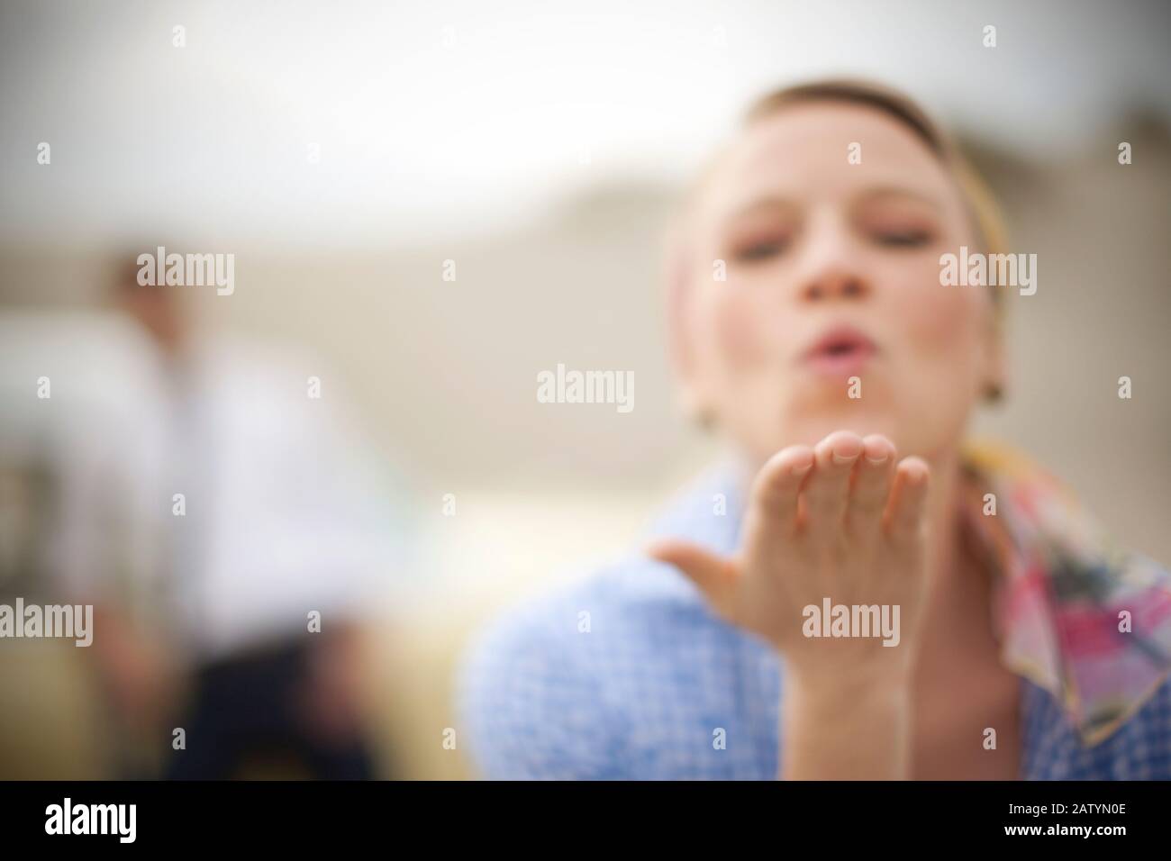 Young woman in 1950s outfit blowing kiss to camera Stock Photo