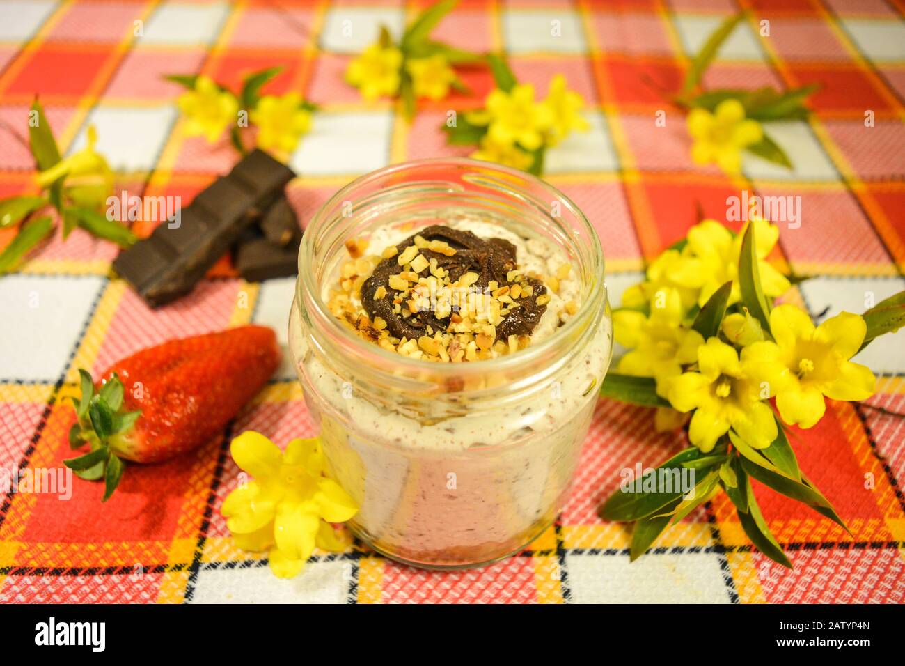 A sweet creation for wedding celebration, stracciatella cheesecake in a cup with chocolate and hazelnut decoration, cookie crumble and strawberry base Stock Photo