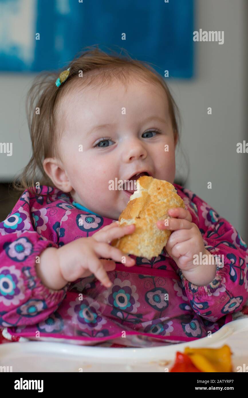 8 month old baby girl eating food Stock Photo - Alamy