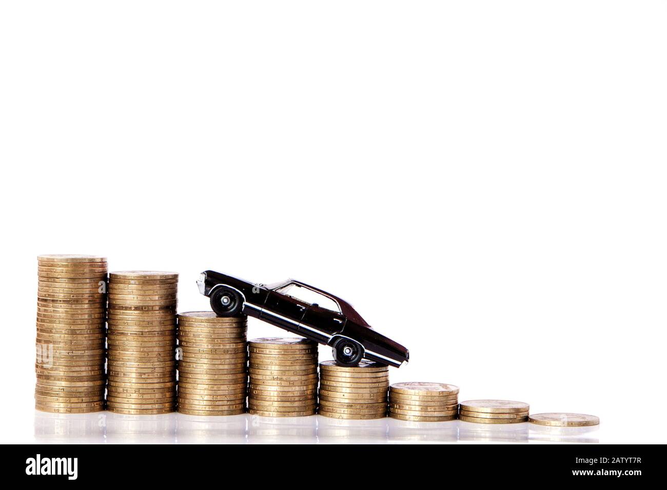 A black model of a car with coins in the form of a histogram on a white background. Concept of lending, savings, insurance. Stock Photo