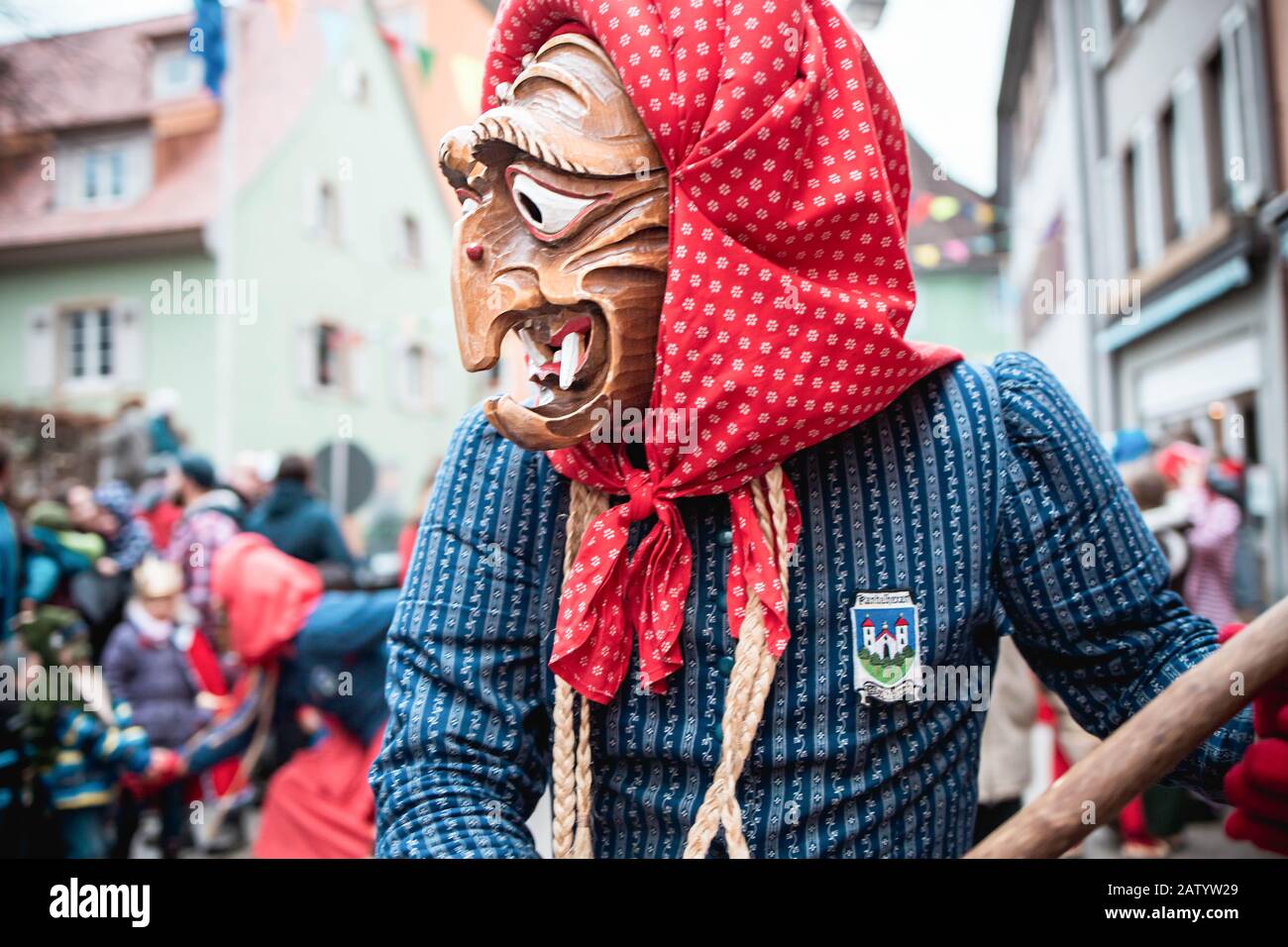 Kandel witch from Waldkirch, beautiful witch in a blue and red robe looks into the audience during the carnival parade in Staufen, southern Germany Stock Photo