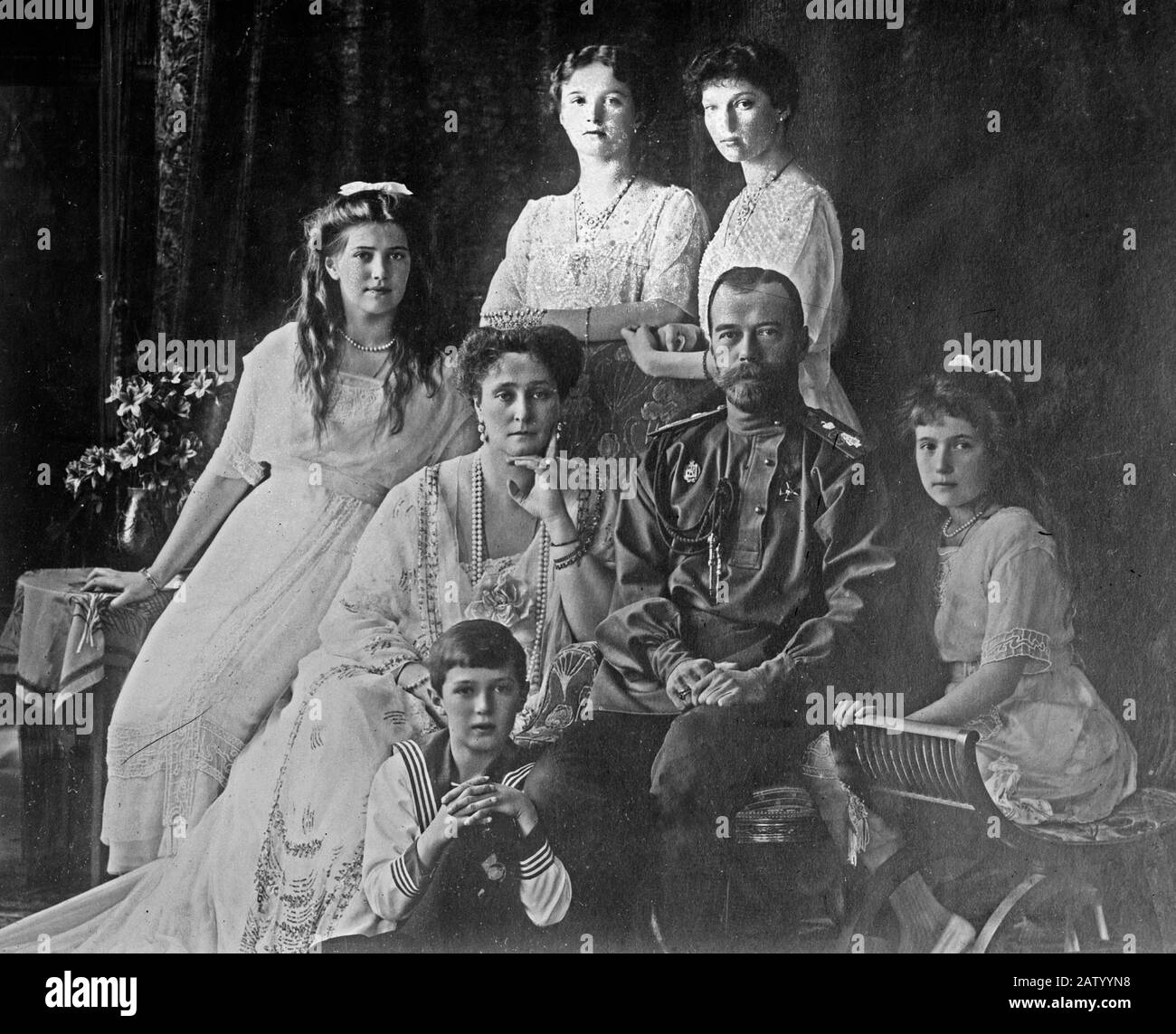 Members of the Romanovs, the last royal family of Russia including: seated (left to right) Marie, Queen Alexandra, Czar Nicholas II, Anastasia, Alexei (front), and standing (left to right), Olga and Tatiana ca. 1914 Stock Photo