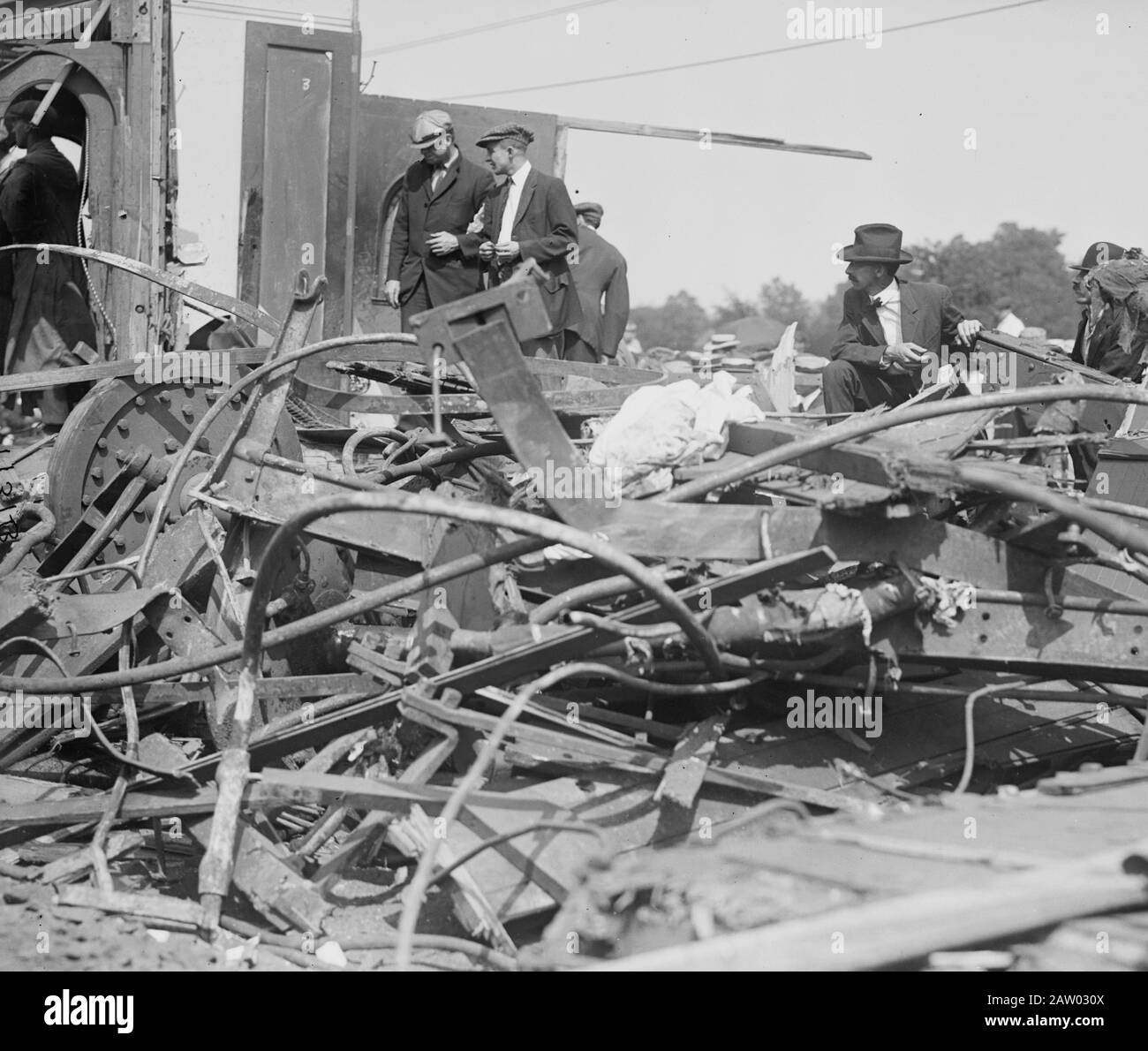 People looking at wrecked railroad cars after a railroad accident in
