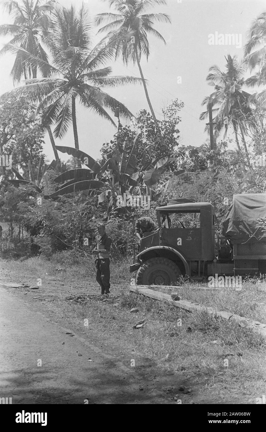 Bandung convoy  [motor of a three-tonner is checked while another soldier standing guard] Date: 1946 Location: Indonesia Dutch East Indies Stock Photo