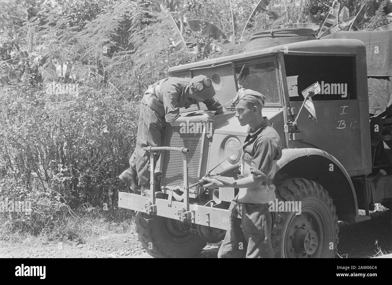 Bandung convoy  [motor of a three-tonner is checked while another soldier standing guard] Date: 1946 Location: Indonesia Dutch East Indies Stock Photo