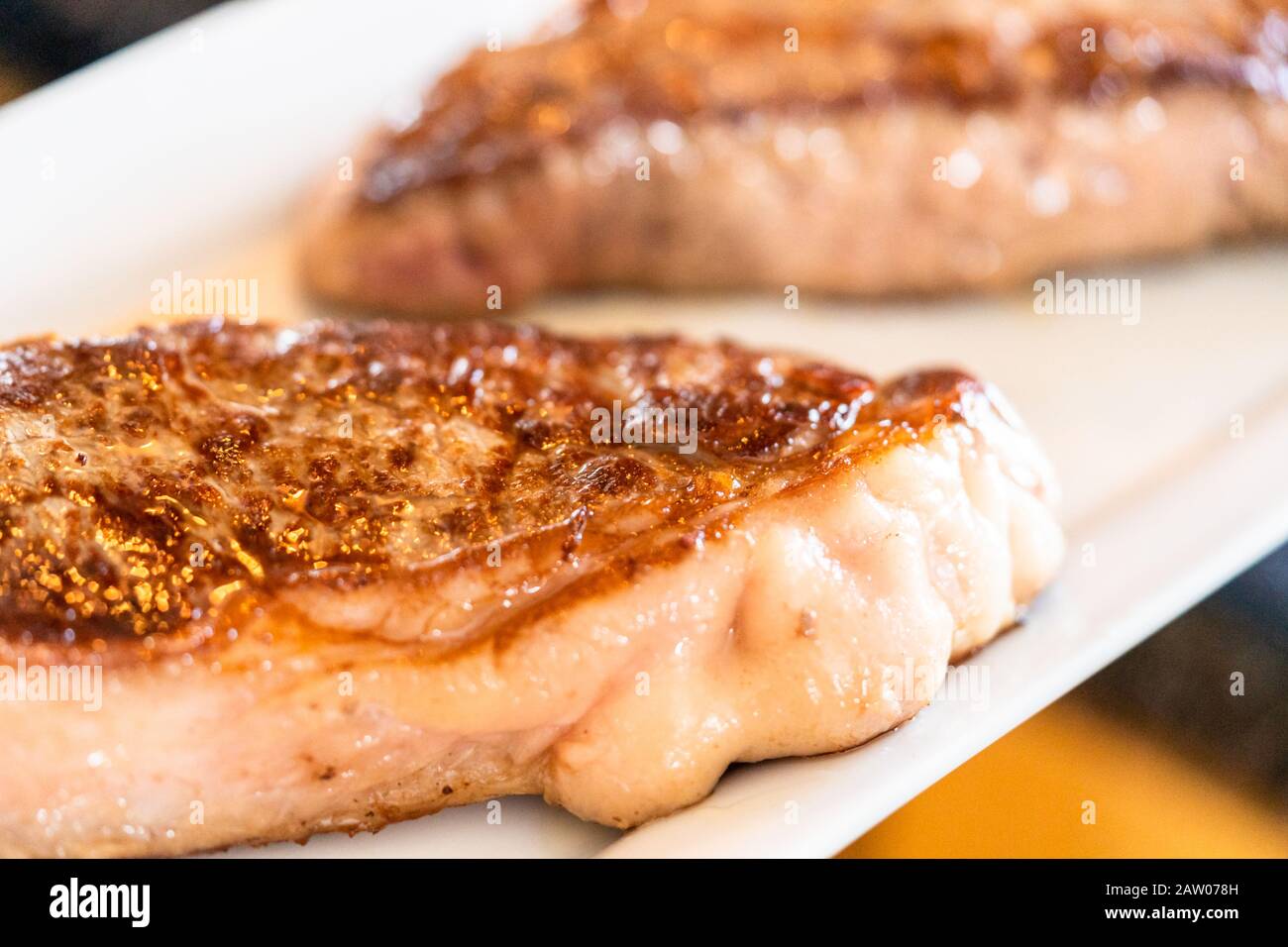 Frying New York strip steak in cast iron frying pan over the electric stove Stock Photo Alamy